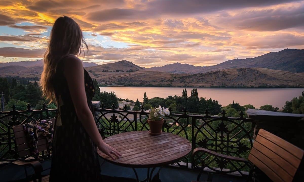 woman standing at a patio near a table in queenstown new zealand 1200x720 1